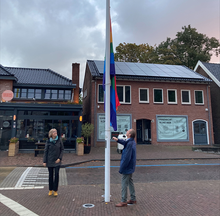 Burgemeester Jan Willem Boersma en wethouder Margreet de Deugd hijsen de regenboogvlag